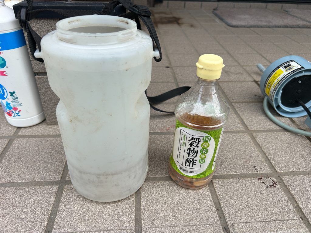 2026年8月18日のおーしん菜園で野菜への散布用に噴霧器と穀物酢を準備している様子